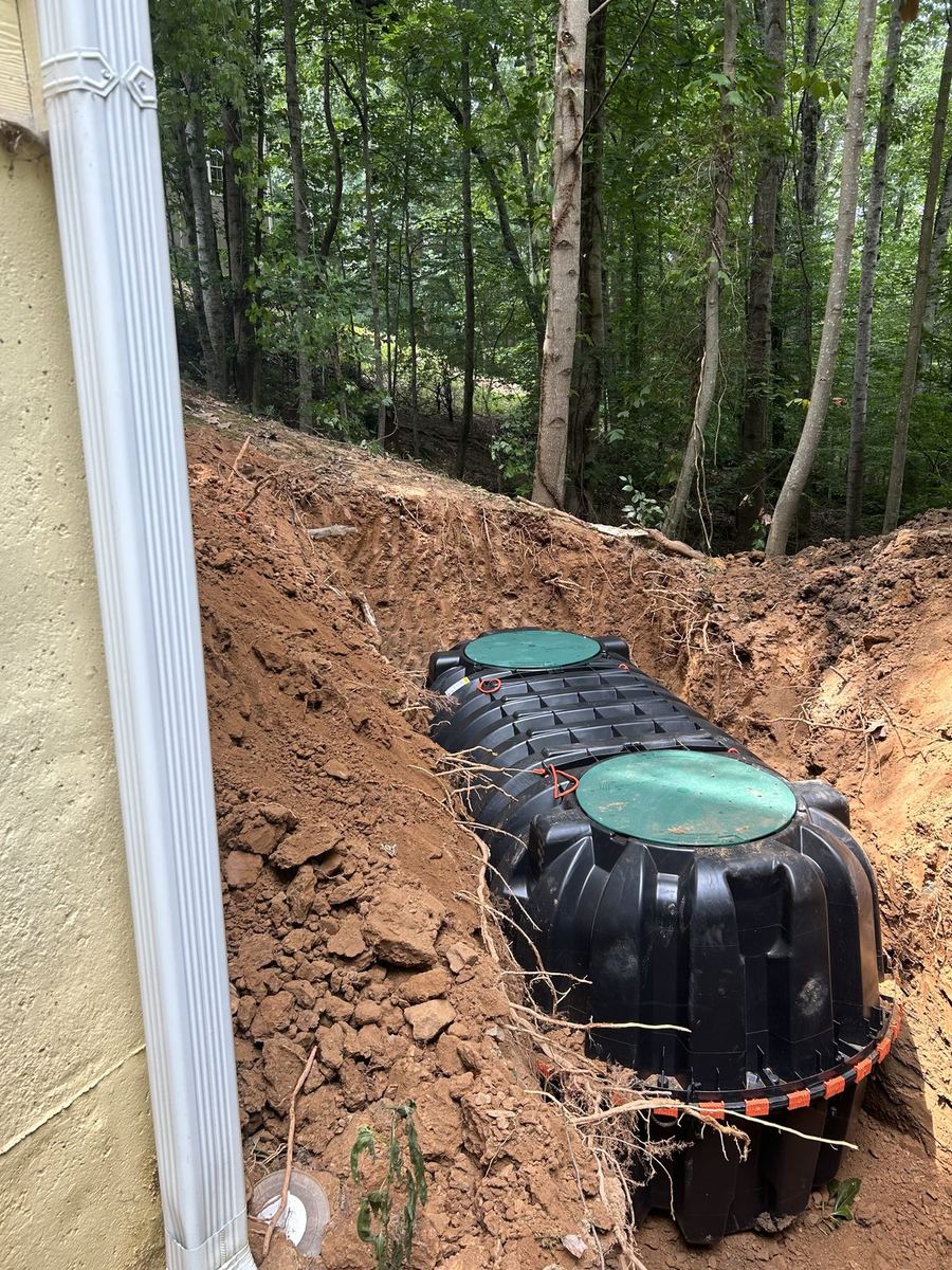 Two-compartment tank fresh in the excavation, ready for risers.