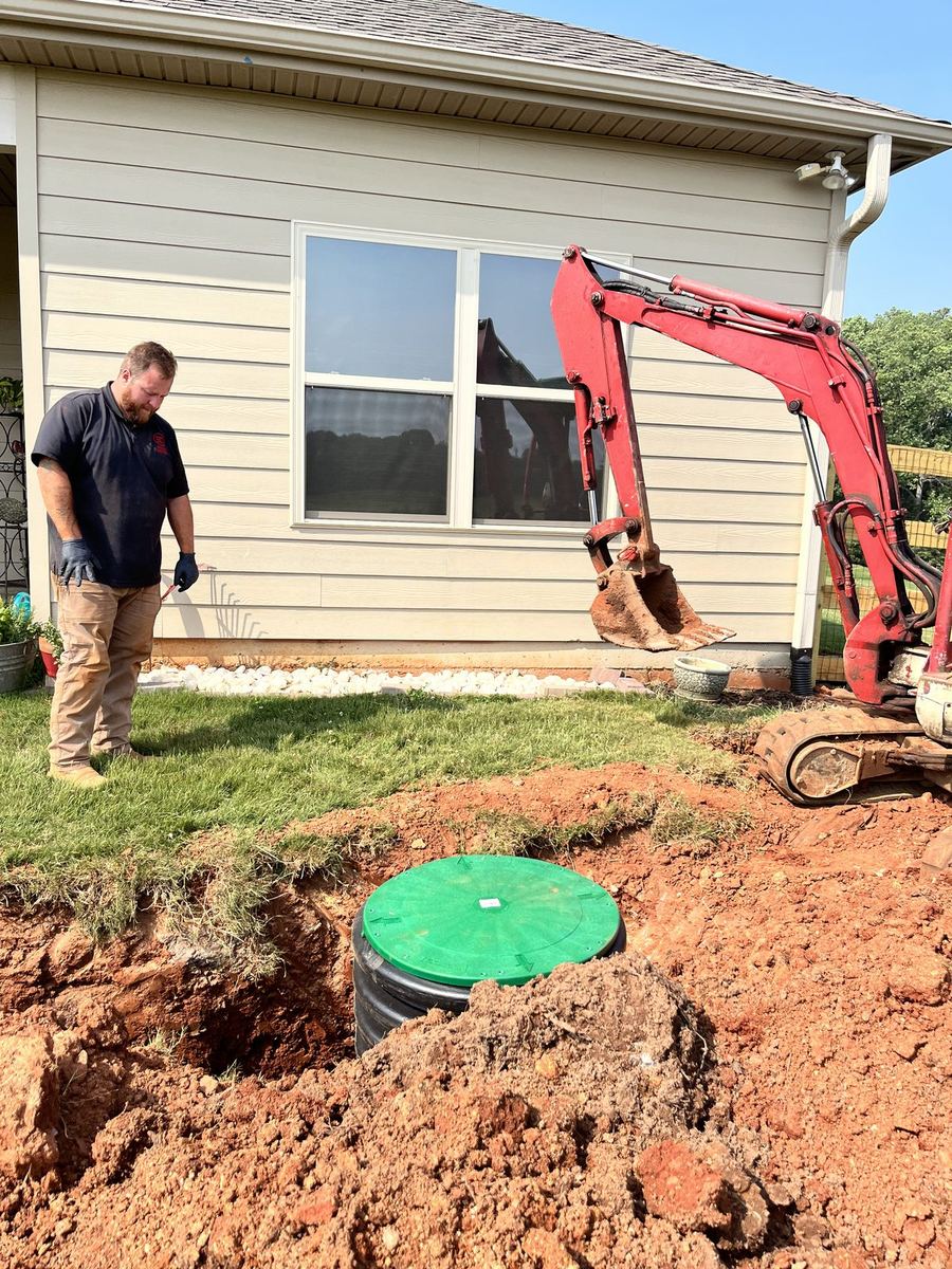 Green tank riser cleanout installed beside home